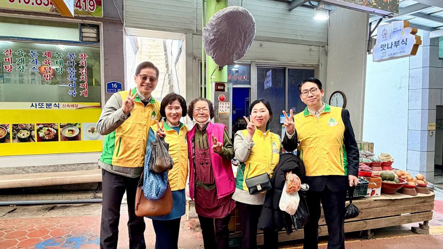 지난 19일 신천지자원봉사단 거제지부가 옥포전통시장에서 지역의 상권을 살리기 위한 ‘전통시장 장 보기’ 캠페인을 실시한 가운데 지역상인과 기념촬영을 하고 있다(사진 신천지자원봉사단 거제지부)..jpg